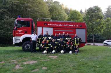 Gruppenfoto der Betreuer der Jugendfeuerwehr vor Einsatzwagen