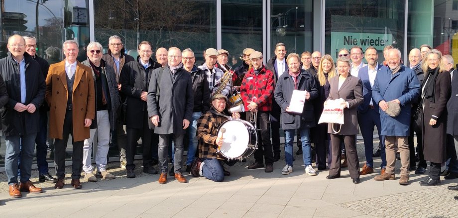 Bürgermeister und Kämmerer mit der Band „It's live“ vor dem Konrad-Adenauer-Haus.
Der Pirmasenser Bürgermeister Michael Maas übergibt in Berlin den Forderungskatalog der Bündnis-Kommunen an den CDU-Bundestagsabgeordneten Florian Bilic.