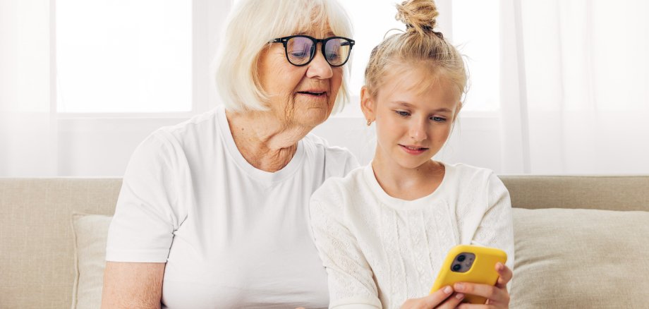 Granddaughter selfie grandmother education bonding child hugging family sofa smiling phone togetherness